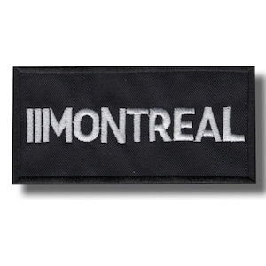 Peut inclure: Écusson rectangulaire noir brodé avec le mot "MONTREAL" en lettres majuscules blanches. Le patch a une bordure noire et un effet d'ombre.