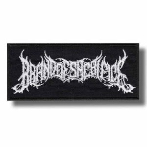Può includere: Toppa rettangolare nera con testo ricamato bianco. Il testo è stilizzato in un font gotico. La toppa è probabilmente per abbigliamento o accessori, e il design suggerisce un tema musicale heavy metal o rock.