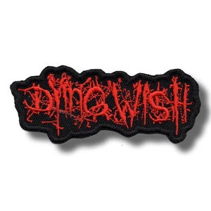 Peut inclure: Un écusson brodé noir avec le texte "Dying Wish" en rouge. L'écriture est stylisée et le bord est irrégulier. Ce patch est conçu pour être cousu sur des vêtements ou des accessoires.