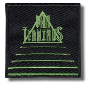 May include: Black square patch with green embroidered text and design. The text reads "DAN TERMINUS" above horizontal lines. The design includes a triangle shape above the text. The patch has a black border.