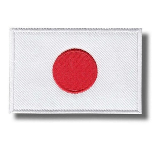 Może przedstawiać: Haftowana naszywka przedstawiająca flagę Japonii. Naszywka ma białe tło z centralnym czerwonym okręgiem, reprezentującym słońce. Prostokątna naszywka ma białą obwódkę i prawdopodobnie jest przeznaczona do aplikacji na odzieży lub akcesoriach.