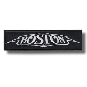 Peut inclure: Écusson rectangulaire noir avec le mot "BOSTON" brodé en blanc, dans une police stylisée avec des éclairs. Idéal pour les vêtements ou accessoires.