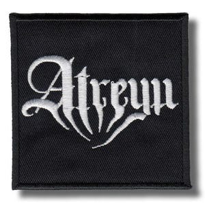 May include: A black square patch featuring the word "Atreum" embroidered in white gothic lettering. The patch has a black border and is designed to be sewn onto clothing or accessories.