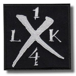 Puede incluir: Parche cuadrado negro con diseño bordado en blanco. El diseño presenta una gran "X" blanca con los números "1" y "4" y las letras "L" y "K" alrededor de la "X".