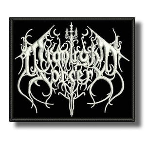 Op de afbeelding: Een zwart, rechthoekig embleem met witte geborduurde tekst. De tekst is gestileerd met een gotisch lettertype. Het embleem heeft een zwarte rand en is waarschijnlijk bedoeld om op kleding of accessoires te naaien. Het ontwerp heeft een heavy metal esthetiek.