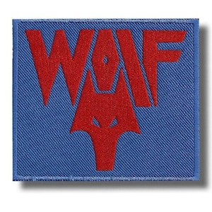 Könnte beinhalten: Gestickter Aufnäher mit den roten Buchstaben "WAF" über einem roten Wolfskopf-Design auf blauem Hintergrund. Der Aufnäher hat eine quadratische Form mit blauem Rand. Geeignet für Jacken oder Taschen.