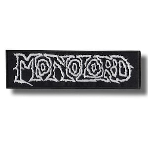 May include: Black rectangular patch with the word "MONOLORD" embroidered in white. The lettering has a stylized, swirling design. The patch is likely for clothing or accessories.