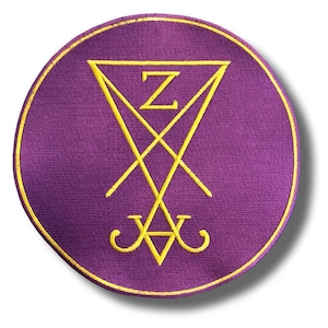 May include: A circular purple patch with a gold border. The patch features a yellow sigil design with a triangle, intersecting lines, and the letter "Z". The design is centered on the patch.