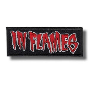 Könnte beinhalten: Schwarzer rechteckiger Aufnäher mit dem gestickten Schriftzug "IN FLAMES" in Rot mit weißer Umrandung. Der Text hat ein tropfendes, flammenartiges Design. Geeignet für Jacken oder Taschen.