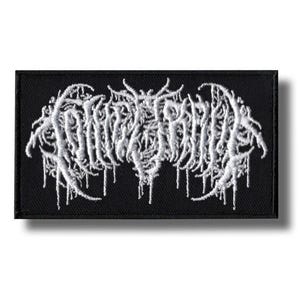 May include: A black rectangular patch with white embroidered text. The text is stylized and appears to be a band name or logo. The design has a gothic or metal aesthetic, with a dripping effect.