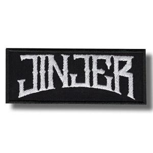 Könnte beinhalten: Schwarzer rechteckiger Aufnäher mit dem Wort "JINJER" in weißer, stilisierter, gotischer Schrift gestickt. Der Aufnäher hat einen schwarzen Rand und ist wahrscheinlich zum Aufnähen oder Aufbügeln auf Kleidung oder Accessoires gedacht.