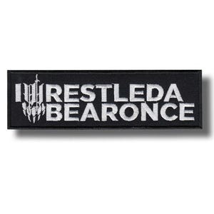 Op de afbeelding: Een rechthoekige zwarte patch met witte geborduurde tekst en een afbeelding. De tekst luidt "RESTLEDA BEARONCE" met een gestileerd ontwerp aan de linkerkant. De patch is bedoeld voor kleding of accessoires.