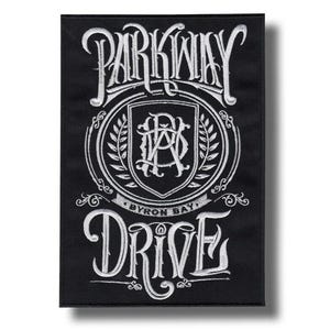 Peut inclure: Écusson rectangulaire noir avec texte brodé blanc. Le texte indique "PARKWAY DRIVE" en haut et "DRIVE" en bas, avec un écusson au centre. L'écusson comprend le texte "BYRON BAY".