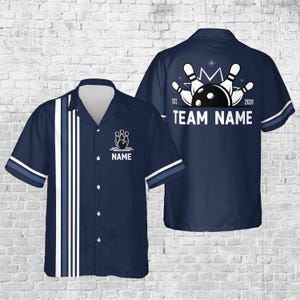 May include: Navy blue bowling shirt with white and blue stripes down the front. The shirt features a bowling pin and ball graphic with the word "NAME" below it. The back of the shirt has a bowling graphic and the words "TEAM NAME".