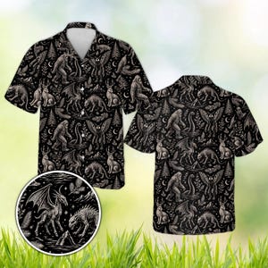 May include: A black short-sleeve button-down shirt featuring an all-over white line art pattern of mythical creatures including Bigfoot, the Loch Ness Monster, Mothman, and jackalopes, interspersed with pine trees, stars, and crescent moons.