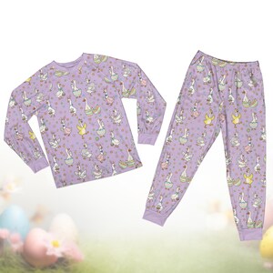 Op de afbeelding: Set van drie keramische mokken met een gespikkelde, cr&egrave;mekleurige glazuur. Elke mok heeft een handgeschilderd bloemmotief in blauw, groen en geel. De mokken hebben een eenvoudige, afgeronde vorm en een handvat.