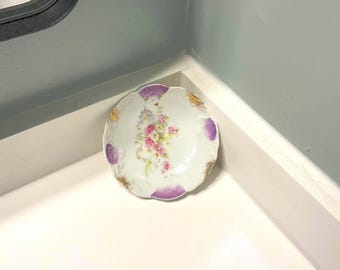 Plato de tocador vintage de porcelana con forma de flor morada.