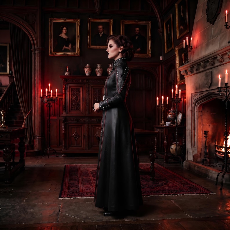 May include: A floor-length black leather coat featuring a high collar, long sleeves, and vertical rows of silver studs along the front placket and shoulders. The coat has a fitted bodice that transitions into a full-length skirt with a smooth finish.