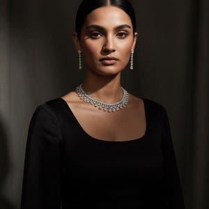 Peut inclure: Une femme porte un collier de diamants et des boucles d'oreilles assorties. Les bijoux sont mis en valeur sur une robe noire à col carré. L'image est bien éclairée, soulignant l'éclat des pierres blanches. Le texte "N-1559-WHITE" est visible en bas.