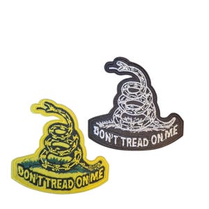 May include: Two embroidered patches with a coiled snake and the text "DON'T TREAD ON ME." One patch has a yellow background with a green base, and the snake is yellow. The other patch has a black background with a white snake.