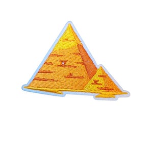 Könnte beinhalten: Gestickter Aufnäher mit einer stilisierten Darstellung der Pyramiden von Gizeh. Der Aufnäher zeigt eine große Pyramide und eine kleinere, in Gelb- und Orangetönen mit einem hellblauen Rand. Das Design ist mit strukturierten Nähten detailliert.
