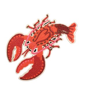 Op de afbeelding: Geborduurde patch met een gedetailleerd rood kreeftontwerp. De patch heeft een levendig kleurenpalet met tinten rood, roze en bruin en is omlijnd met een crèmekleurige rand. De scharen en het lichaam van de kreeft zijn ingewikkeld gestikt.