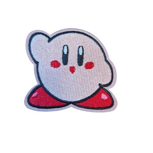 May include: Embroidered patch of a cartoon character with a light pink body, red cheeks, and black eyes. The character has a red base and a light pink outline. The patch is designed for application on clothing or accessories.