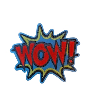 May include: Embroidered patch featuring the word "WOW!" in red, outlined in black, against a blue background. The word is in a bold, comic book style font, with a yellow and black burst design around the text. The patch is likely for clothing or accessories.