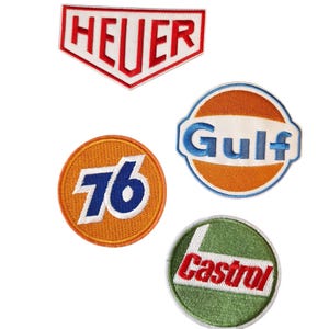 Può includere: Quattro toppe ricamate con loghi vintage. Le toppe includono il logo Heuer in rosso e bianco, il logo Gulf in blu e arancione, il logo 76 in blu e arancione e il logo Castrol in rosso e verde.