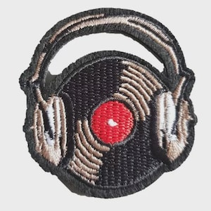 Pode incluir: Patch bordado com um disco de vinil preto com centro vermelho e ranhuras bege, sobreposto por auscultadores. Os auscultadores e o disco são delineados em preto, com detalhes em bege e branco. O patch foi concebido para aplicação em roupa ou acessórios.