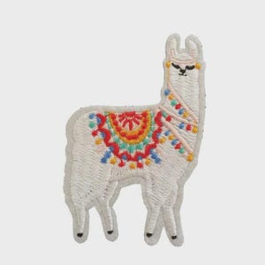 Può includere: Toppa ricamata raffigurante un lama bianco con un design di coperta colorata. La coperta presenta dettagli rossi, gialli, blu e verdi. Il lama ha occhi neri e un copricapo rosa. Adatta per abbigliamento o accessori.