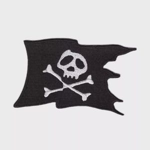 Puede incluir: Parche de bandera pirata negra con un diseño de calavera y huesos cruzados blancos. La bandera tiene un borde rasgado, lo que le da un aspecto desgastado. Ideal para añadir un toque pirata a la ropa o accesorios.