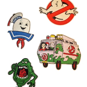 May include: Four embroidered patches featuring Ghostbusters characters and symbols. Includes the Stay Puft Marshmallow Man, a no-ghost logo, Slimer, and the Ecto-1 vehicle. Patches are in various colours, including white, red, green, and blue.