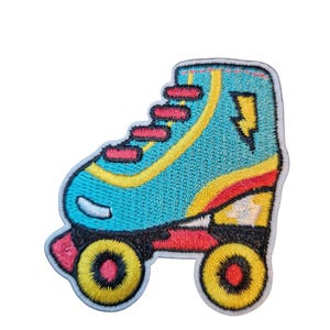 Op de afbeelding: Geborduurde patch van een rolschaats. De schaats is turquoise met gele en rode accenten, een gele bliksemschicht en gele wielen. De veters zijn rood.