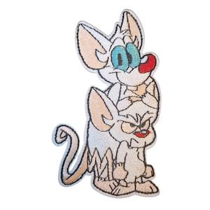 Puede incluir: Parche bordado con dos ratones de dibujos animados. El ratón superior tiene grandes ojos azules y una nariz roja. El ratón inferior tiene una expresión severa con la boca roja. El parche es blanco con detalles en beige.