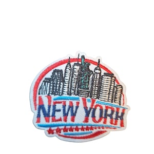 May include: Embroidered patch depicting the New York City skyline, with the words "NEW YORK" in red and blue. The patch has a white background and a red border, showing famous buildings.