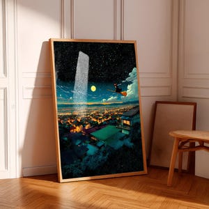 May include: A framed art print depicts a nighttime cityscape with a starry sky, a full moon, and a figure on a broom. The artwork features a wooden frame and is leaning against a white wall. The scene is illuminated by city lights.
