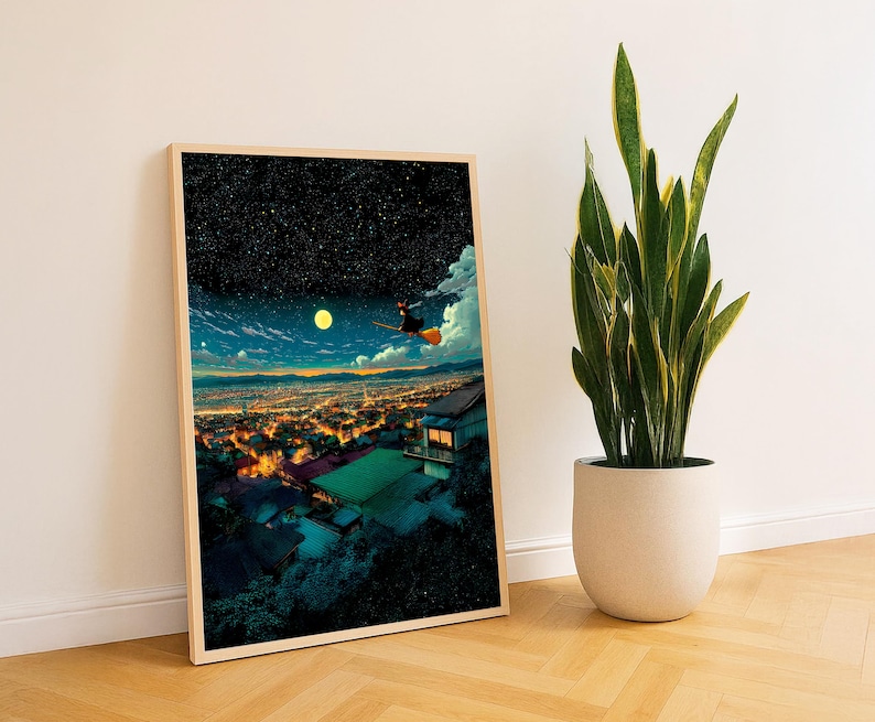 May include: A framed art print depicts a witch flying on a broom over a city at night, under a starry sky and a full moon. The artwork has a warm color palette with a wooden frame. A potted snake plant is next to the framed art print.
