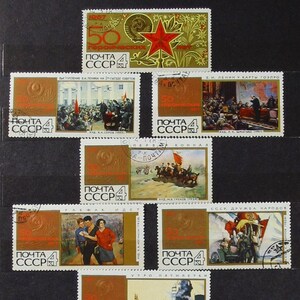 Può includere: Una collezione di francobolli sovietici vintage, con varie illustrazioni e testo. I francobolli raffigurano eventi storici, tra cui immagini di Lenin, celebrazioni e scene architettoniche. I francobolli sono in tonalità di marrone, oro e rosso.