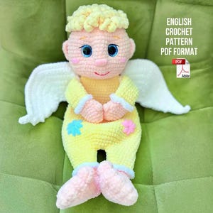 May include: A handmade crochet angel doll with a yellow outfit, light yellow hair, and white wings. The doll has blue eyes, pink cheeks, and a small red smile. The text "ENGLISH CROCHET PATTERN PDF FORMAT" is visible.