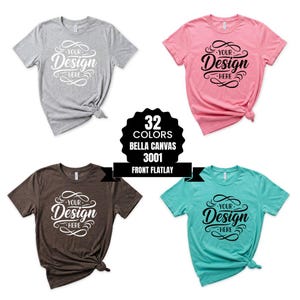 Könnte beinhalten: Vier Bella Canvas 3001 T-Shirts in Grau, Rosa, Braun und Türkis. Jedes Shirt zeigt den Text "Your Design Here" in dekorativer Schrift. Ein schwarzes Abzeichen zeigt 32 verfügbare Farben an.