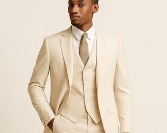 May include: A three-piece suit in a light beige color. The suit includes a jacket, vest, and trousers. A white collared shirt and a patterned tie complete the ensemble. The suit is tailored and appears to be made of a lightweight fabric.