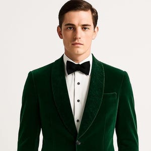 May include: A dark green velvet blazer, black bow tie, and white dress shirt. The blazer features a notched lapel and a single-button closure. The ensemble is formal and elegant, suitable for special occasions.