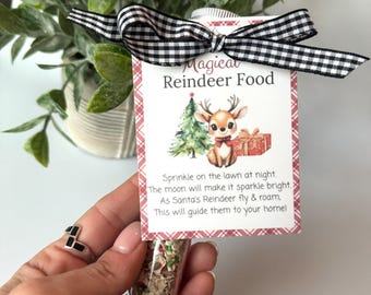 May include: A clear glass vial filled with reindeer food, held by a hand. A tag with the text "Magical Reindeer Food" and a reindeer illustration is attached with a black and white checkered bow. The tag includes text about sprinkling the food.