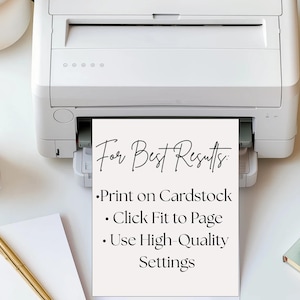 May include: A white printer printing a sheet of paper with the text "For Best Results: Print on Cardstock, Click Fit to Page, Use High-Quality Settings." A cup of coffee, a pen, and a notebook are on the white surface.