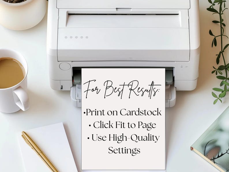 May include: A white printer printing a sheet of paper with the text "For Best Results: Print on Cardstock, Click Fit to Page, Use High-Quality Settings." A cup of coffee, a pen, and a notebook are on the white surface.
