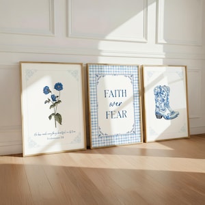 May include: Three framed wall art prints with a blue and white color scheme. The left print shows blue flowers with the text He has made everything beautiful in its time Ecclesiastes 3:11. The center print features the text FAITH over FEAR. The right print displays a blue and white floral cowboy boot.