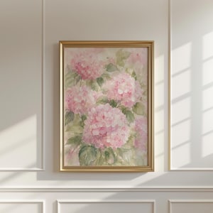 May include: A vertical rectangular wall art piece featuring a watercolor painting of soft pink hydrangea flower clusters with muted green leaves, enclosed within a thin, metallic gold frame that highlights the delicate floral composition.