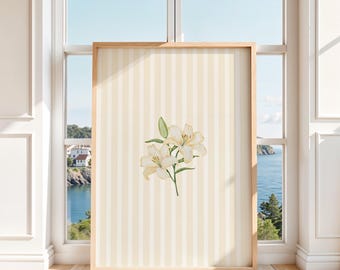 May include: A rectangular framed wall art piece featuring a vertical cream and white striped background with a central illustration of two white lily flowers with green stems and leaves, enclosed in a light-toned wooden frame.