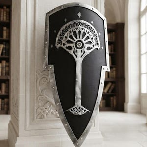May include: A heater-style shield with a matte black surface and a metallic silver border featuring visible rivets. A large, intricate silver tree emblem with a fan-shaped canopy and star-like accents is centred on the shield's front face.